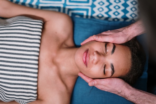 A woman having wholesale organic essential oils applied topically to her face for breathing.